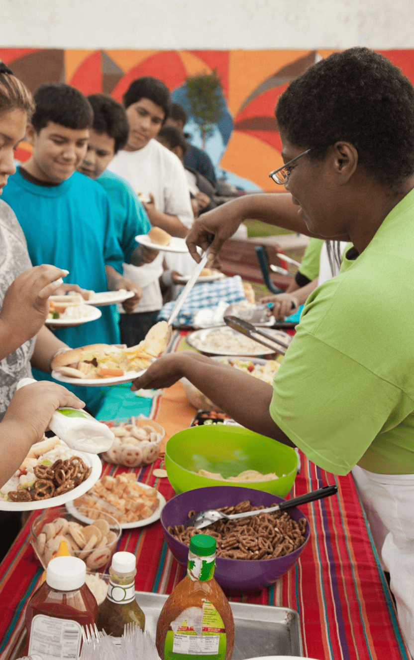 Women helping people in public kitchen